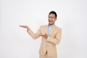 A handsome Asian businessman is opening his palms aside at an empty space on an isolated background.