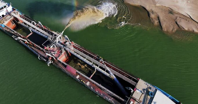 Aerial shot of a dredger unloading dredged sand on a big river, sunny day