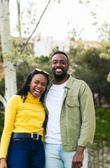 portrait of a black couple laughing in a park