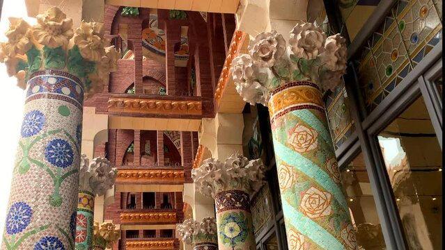 Colorful mosaic tiles decorate columns on the balcony of the  Palace of Catalan Music, Palau de la M&uacute;sica Catalana.  The venue is an architectural jewel of Catalan Art Nouveau. Pan up for detail.