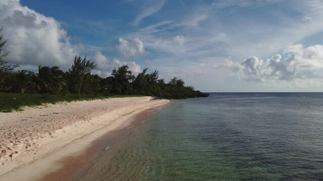 Low angle drone shot of a white sand beach
