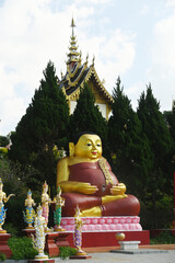 Statue of outdoor Happy Buddha decoration at the entrance to the Wat Saeng Kaew Phothiyan temple. Located at Chiang Rai Province in Thailand.