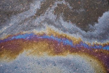 Multi colored oil spill on asphalt road, abstract background,