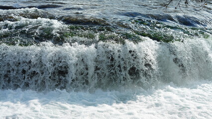 The beautiful river view with the running water and colorful forest as background in autumn