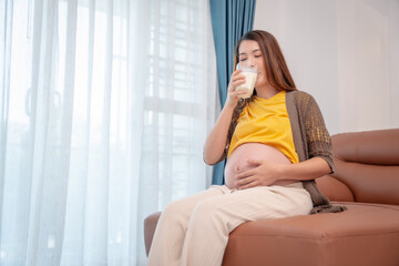 Pregnant woman drinking milk at home