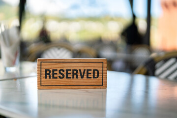 A wooden reserved sign that placed on the dining table at the luxury restaurant for booking the...