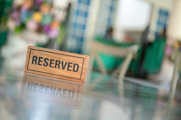 A wooden reserved sign that placed on the dining table at the luxury restaurant for booking the seat. Sign and symbol object photo.
