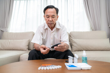 Asian old man check a  sugar level in his blood by him self - 696188158