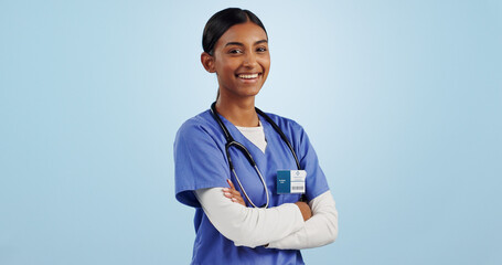 Happy woman, portrait and professional doctor with arms crossed in medical against a blue studio background. Female person, nurse or confident surgeon smile with stethoscope for healthcare on mockup - obrazy, fototapety, plakaty