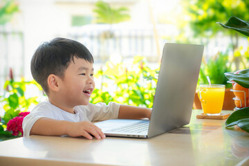 Asian boy fun and watching cartoon video in he computer notebook