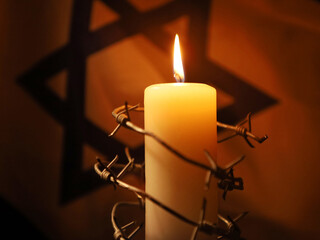 Flag of Israel, barbed wire and burning candle on black background. Holocaust memory day - obrazy, fototapety, plakaty