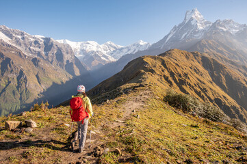 Naklejka na ściany i meble Rear view of female tourist looking to Mt.Machapuchare on Mardi Himal viewpoint, Nepal.