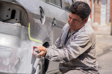 Adult man repairing a car bumper