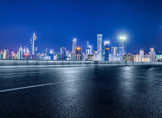 Asphalt road and modern city buildings at night in Shenzhen, China.