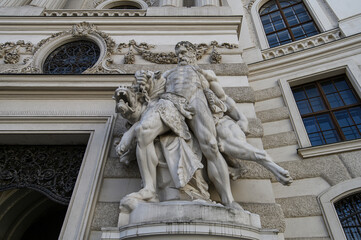 Fototapeta na wymiar Baroque statues on the entrance gate of St. Michael's Wing of Hofburg Palace on Michaelerplatz in Vienna, Austria