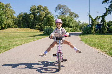 Obraz premium Cheerful child rides on a Bicycle in city park outdoor. 
