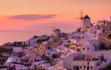 Poster Oia village, Santorini, Greece. View of traditional houses in Santorini. Small narrow streets and rooftops of houses, churches and hotels. Landscape during sunset. Travel and vacation photography. © Pascu