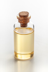 A round glass bottle containing pale yellow color essential oil for cosmetics and natural medicine.