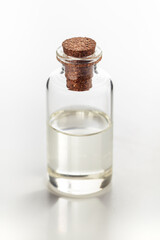 A round glass bottle containing clear transparent essential oil for cosmetics and natural medicine.