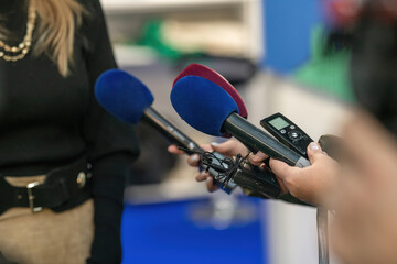 A poised group of journalists with microphones and cameras ready to delve into the heart of an...