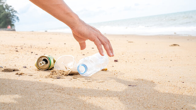 Hand Picking Up Plastic Bottle Cleaning On The Beach. Save The World Concept. Environment, Ecology Care, Renewable Concept,Nature Conservation Tourism