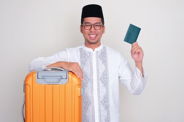 Moslem Asian man with luggage smiling happy and one hand showing passport