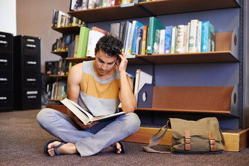 Reading book, floor or student in library at university, college or school campus for education...