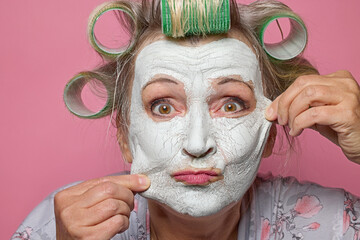 funny senior women with clay face mask