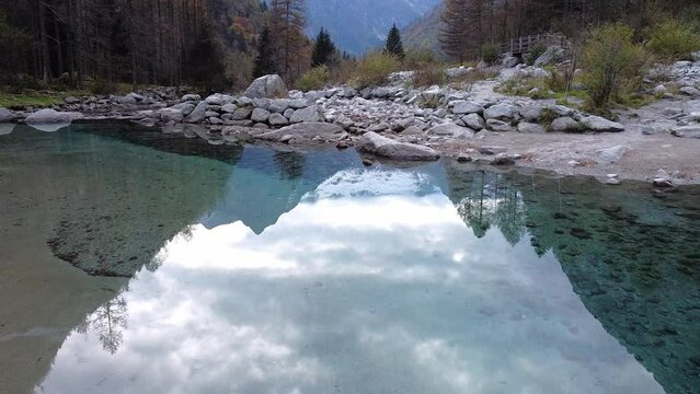 Drone on the forest in Val di Mello, on the river's reflections, Italy