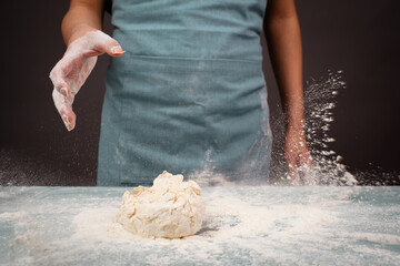 Baker kneading dough for artisan bread or pizza with his hands, prepare ingredients for food, baking pastry
