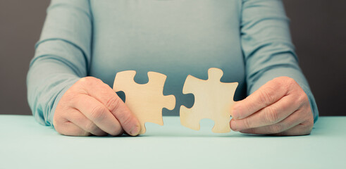Holding two pieces of a puzzle in the hands, connecting together as a team, solving a problem,...