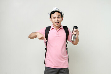 Asian man backpacker hold tumbler bottle and pointing finger gesture. travelling concept. on isolated background