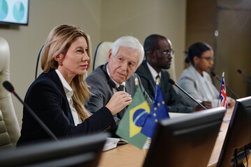 Business people sitting at international conference and asking questions during interview