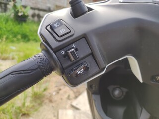 Selectively focus on the left handlebar of an automatic motorbike with the signal light control...