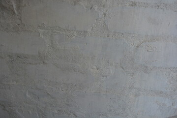 Building background, brickwork made of white brick and gray cement painted with white paint, interesting and unusual background.