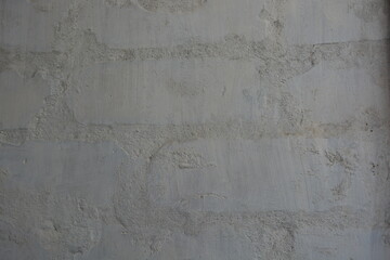 Building background, brickwork made of white brick and gray cement painted with white paint, interesting and unusual background.