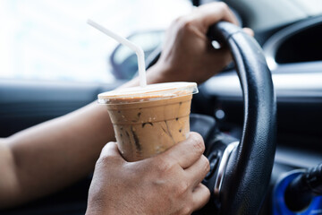 Asian woman driver hold ice coffee cup and sandwich bread for eat and drink in car, dangerous and...