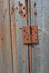 Unusual old wood, wooden boards with old peeling paint with an interesting textured structure with old rusty nails, ancient historical handles, wooden latches, latches and slits.