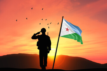 Silhouette of a soldier with the Djibouti flag stands against the background of a sunset or sunrise. Concept of national holidays. Commemoration Day.