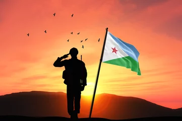 Wall murals Coral Silhouette of a soldier with the Djibouti flag stands against the background of a sunset or sunrise. Concept of national holidays. Commemoration Day.