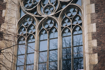 Pointed gothic windows with stained glass on facade of the building. Gothic architecture. Church of...