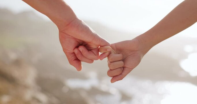 Hands, closeup and pinky promise for people, couple and outdoor at beach with security, trust and love. Partnership, link and synergy for connection, relationship and together on holiday in Brazil