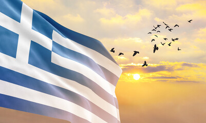 Waving flag of Greece against the background of a sunset or sunrise. Greece flag for Independence...