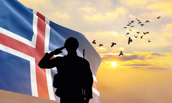 Silhouette of a soldier with the Iceland flag stands against the background of a sunset or sunrise. Concept of national holidays. Commemoration Day. - Powered by Adobe