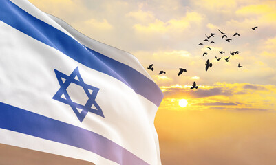 Waving flag of Israel against the background of a sunset or sunrise. Israel flag for Independence Day. The symbol of the state on wavy fabric. - obrazy, fototapety, plakaty