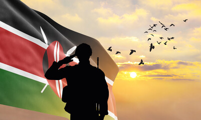 Silhouette of a soldier with the Kenya flag stands against the background of a sunset or sunrise....