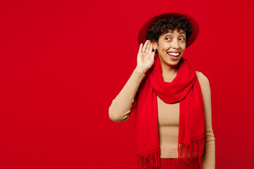 Young curious nosy woman of African American ethnicity she wears beige sweater hat scarf try to...