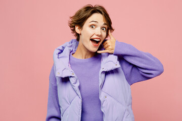Young excited fun cool woman she wear purple vest sweatshirt casual clothes doing phone gesture like say call me back isolated on plain pastel light pink background studio portrait. Lifestyle concept