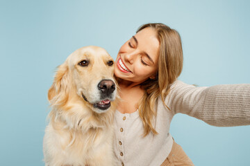 Close up young owner woman with her best friend retriever wear casual clothes do selfie shot on mobile cell phone hug dog isolated on plain pastel light blue background. Take care about pet concept.