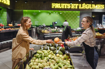 Young customer woman in casual clothes give fruit seller wot measure weight shopping at supermaket...